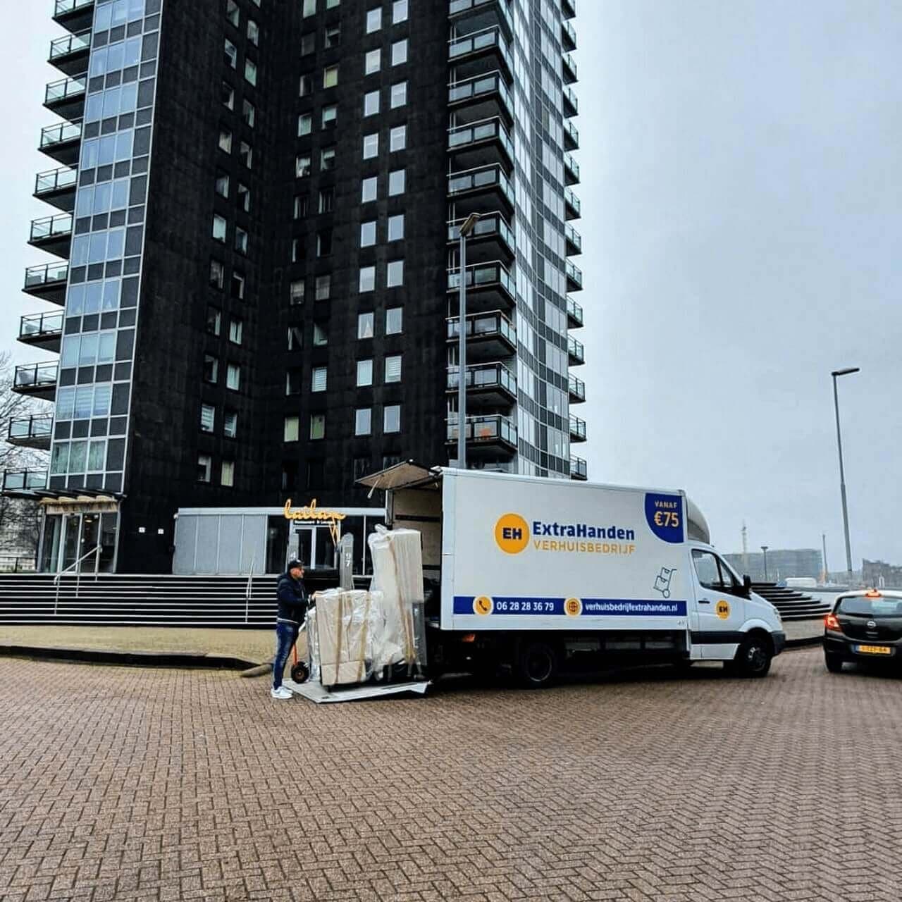 Verhuiswagen van ExtraHanden bij een hoog appartementengebouw